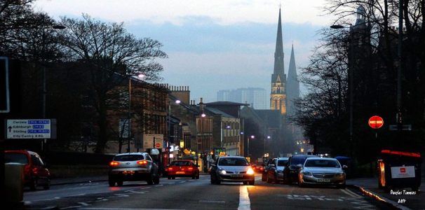 Great Western Road Glasgow this afternoon in the misty twilight. Signpost on the left says all roads lead elsewhere. Taken from the middle of the road.